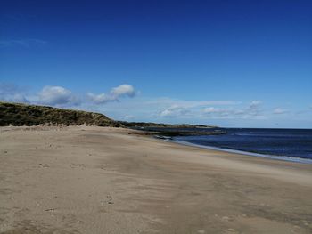 Scenic view of beach against blue sky