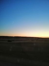 Scenic view of landscape against clear sky during sunset