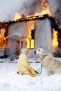 Rescued girl with dog in front of burning house