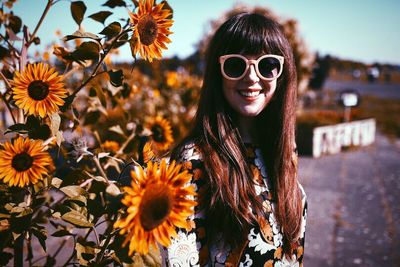 Portrait of woman holding yellow flower
