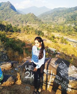 Full length of young woman standing on mountain road