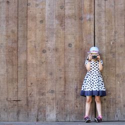 Low section of girl standing on wooden floor