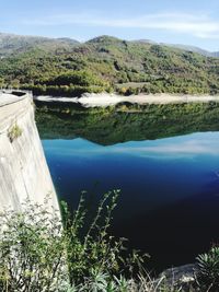 Scenic view of dam by lake against sky