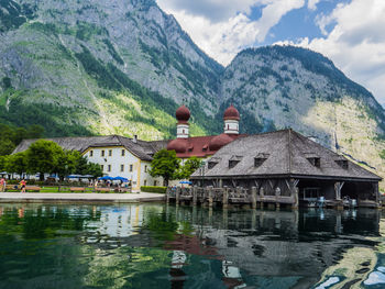 Houses by lake against mountains