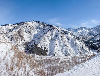 Scenic view of snowcapped mountains against blue sky