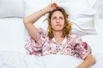 Portrait of young woman lying on bed