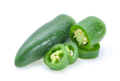 Close-up of wet jalapenos over white background