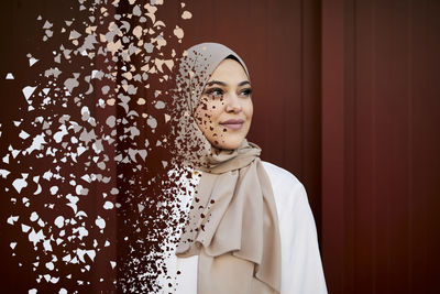 Young woman in headscarf falling into pieces