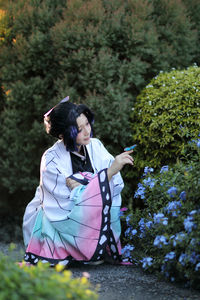 Side view of young woman sitting on field