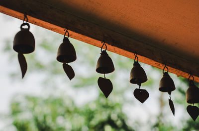 Low angle view of lanterns hanging by building against sky