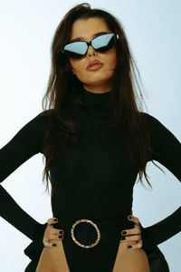 Beautiful young woman standing against white background