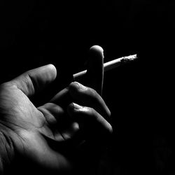 Close-up of hand holding cigarette