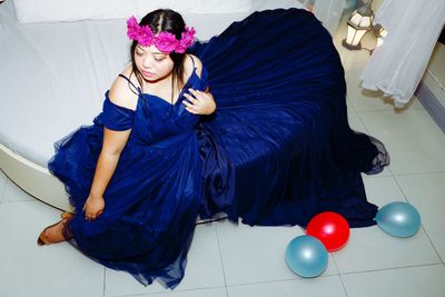 High angle view of woman in dress sitting indoors