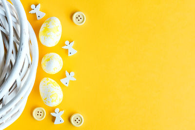 Creative easter layout. yellow white eggs and buttons flat lay background. spring holidays concept.