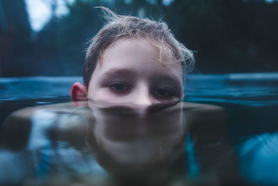 Close-up portrait of boy swimming in lake