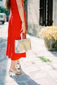 Low section of woman standing on footpath