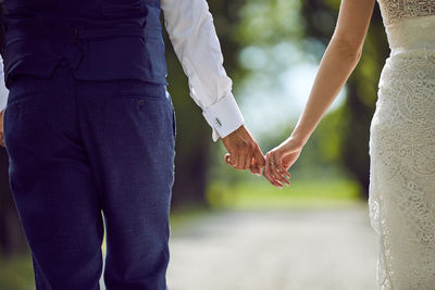 Midsection of couple holding hands