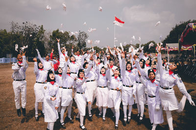 Group of people at flags against sky