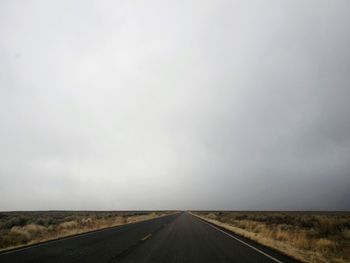 Road passing through landscape against sky