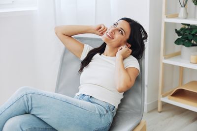 Young woman sitting on sofa at home