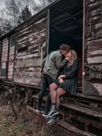 Full length of couple sitting on railroad tracks