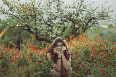 Portrait of woman standing against plants