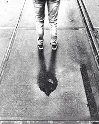 Low section of man standing on puddle