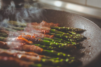 Close-up of asparagus and meat in cooking utensil at home