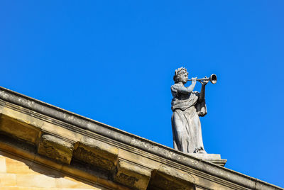 Low angle view of statue against clear blue sky