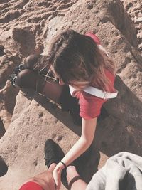Low section of girl sitting on sand