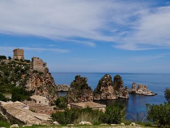 Buildings by sea against sky