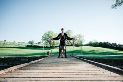 Full length of man standing on field against clear sky