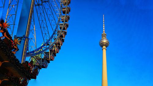 Low angle view of ferris wheel against blue sky