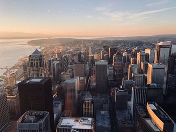 Aerial view of buildings in city against sky during sunset