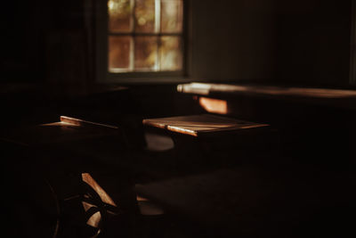 Close-up of electric lamp on table in dark room