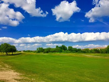 Scenic view of golf course against sky