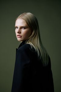 Young woman standing against wall