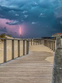 Pier over sea against sky during sunset