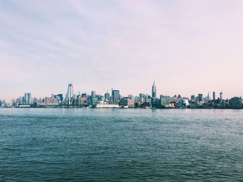 Manhattan by hudson river against sky