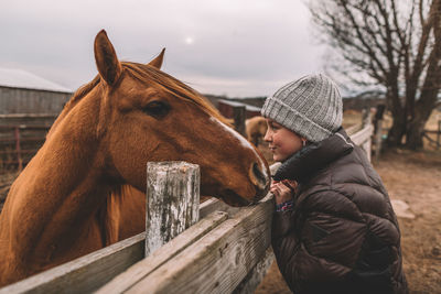 Girl with brown horse making kissy faces