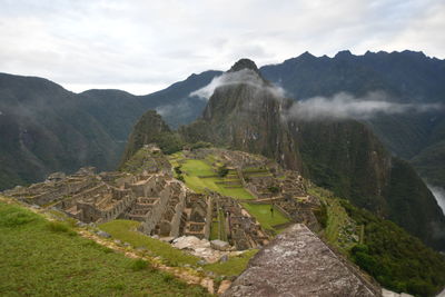 Scenic view of mountain range against cloudy sky