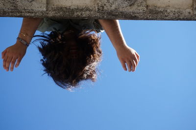 Directly below shot of woman against clear blue sky