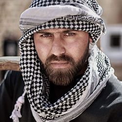 Portrait of serious bearded man wearing headscarf