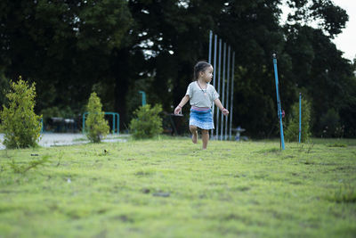 Rear view of boy running on field