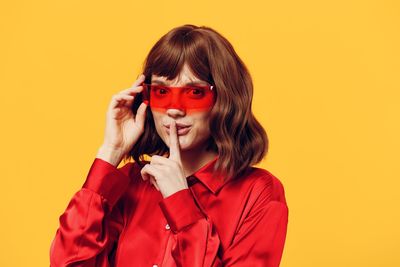 Portrait of young woman against yellow background