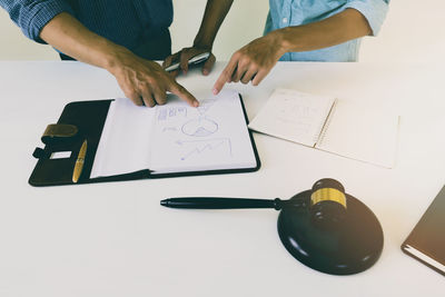 Midsection of business colleagues working on table