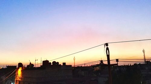 Low angle view of silhouette buildings against clear sky