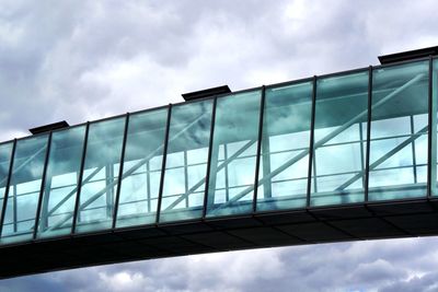 Low angle view of modern building against cloudy sky