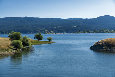 Scenic view of lake and mountains against clear sky