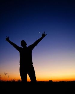 Silhouette woman standing on field against clear sky during sunset